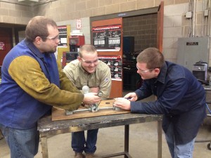 Alumnus Jay O'brien (left) teaches students how to wire an electric circuit. 