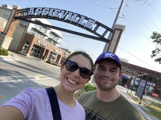 Two K-State students in front of the Aggieville arch over Moro St., Manhattan, Kansas
