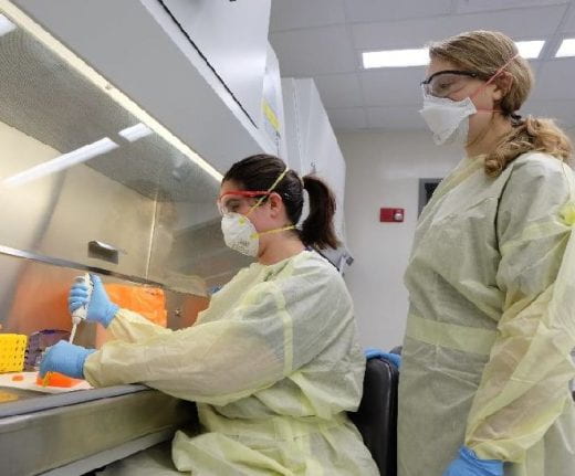 photo of two people at a hood in a lab