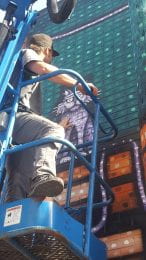Photo of artist Nick Fisher, a.k.a. Sick Fisher, at the mural he painted in downtown Manhattan, KS. 