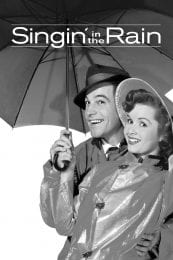 Publicity image of the film "Singin' in the Rain" shpwing actor Gene Kelly and actress Debbie Reynolds holding an umbrella and smiling at the camera (onlooker).