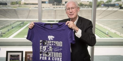 Coach Bill Snyder holding 2018 Fighting for a Cure shirt