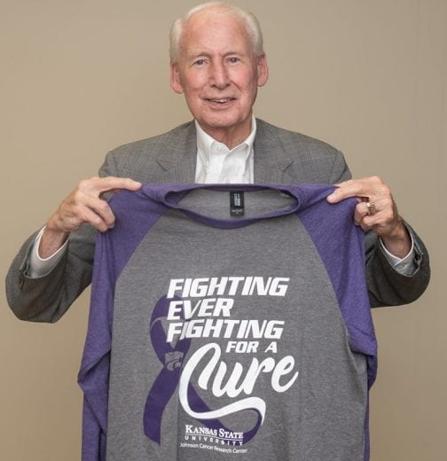 Coach Bill Snyder holding 2021 Fighting for a Cure baseball shirt
